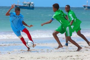 Community members playing beach soccer together